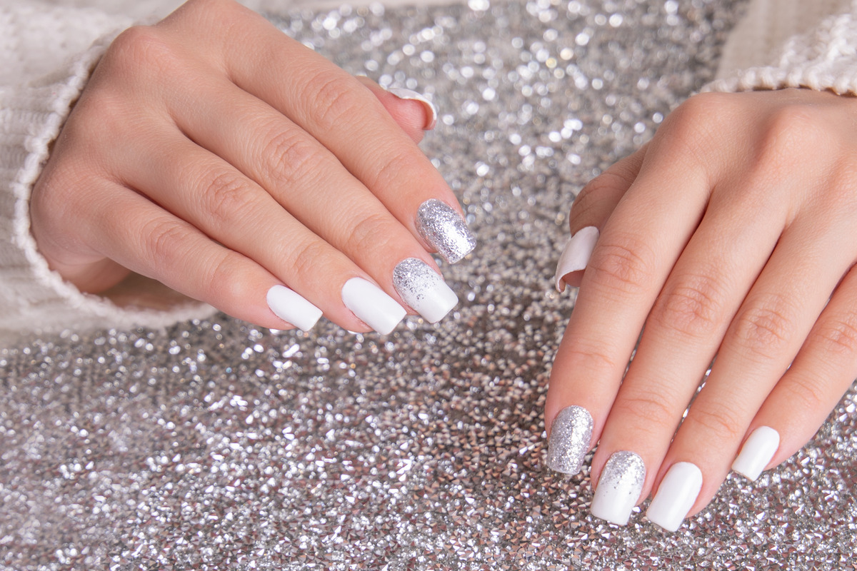 beautiful-female-hands-with-romantic-manicure-nails-white-gel-polish-with-silver-glitter